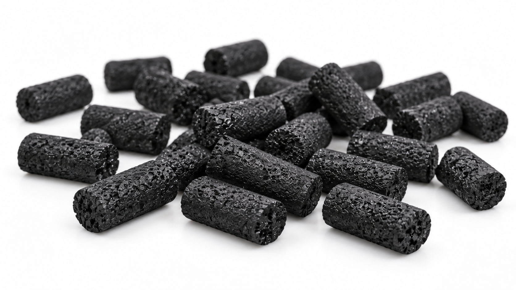 Close-up of scattered black activated carbon pellets